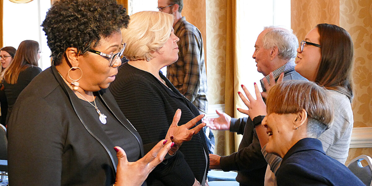 two people talk to each other gesturing emphatically with their hands